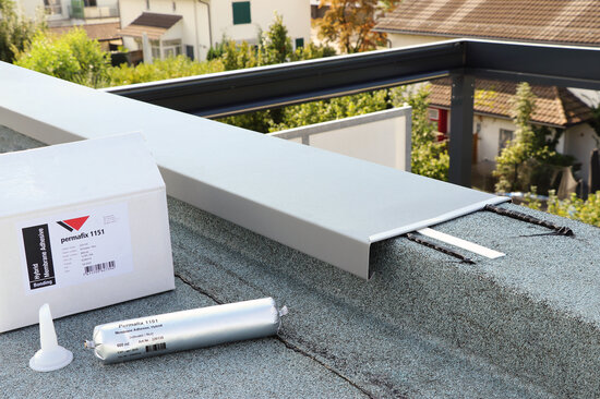Ein Karton und ein Beutel Permafix 1151 neben einem Dachrand-Abschlussblech