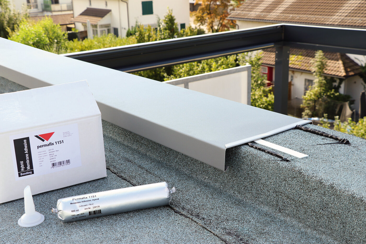 Ein Karton und ein Beutel Permafix 1151 neben einem Dachrand-Abschlussblech