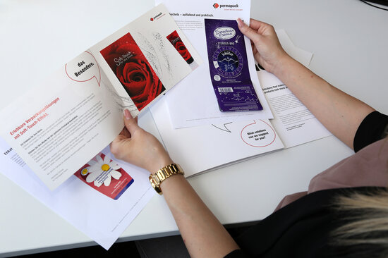 Mitarbeiterin hält verschiedenen Sachet-Muster in der Hand. 