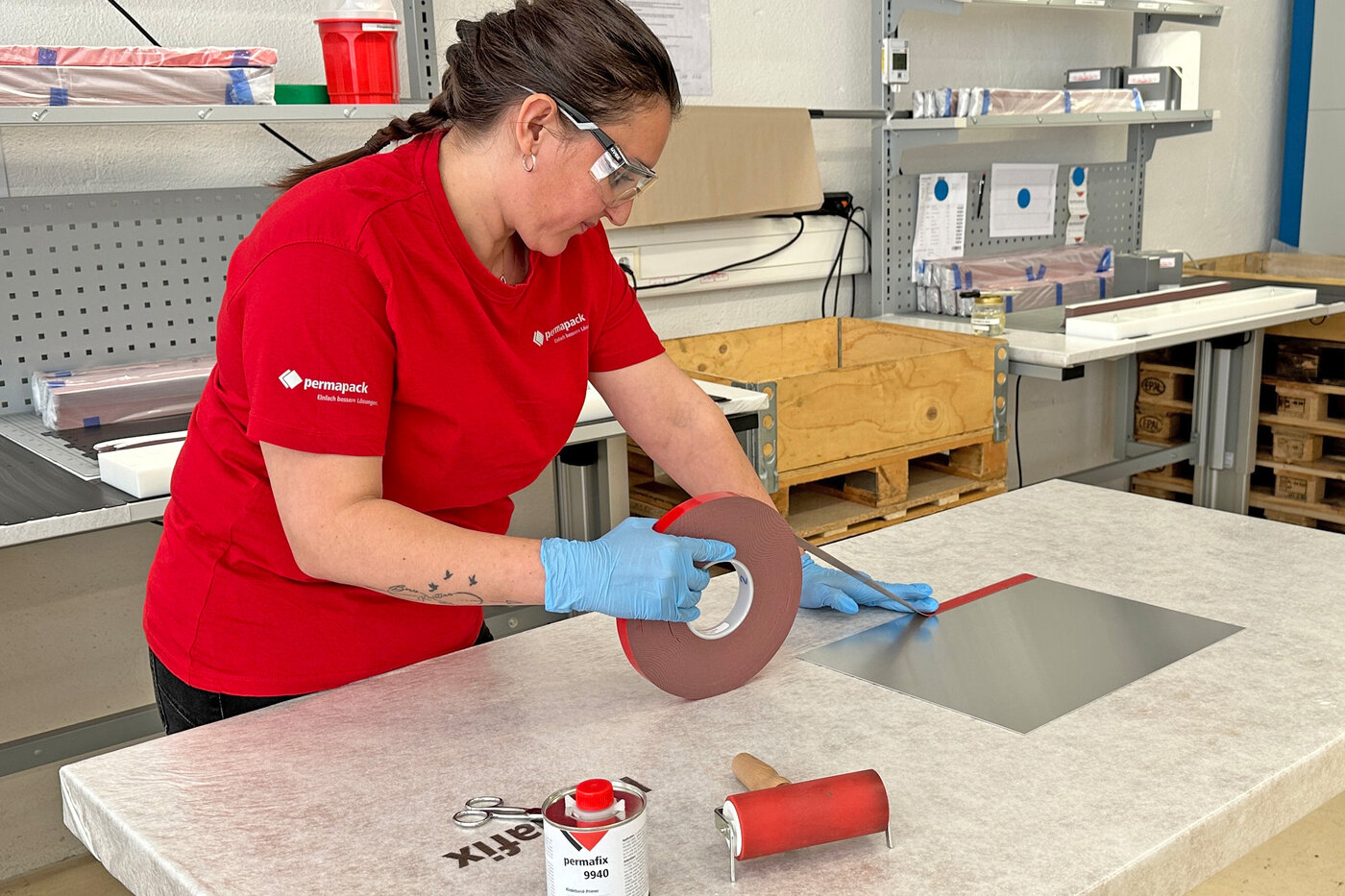 Mitarbeitende beim Ausrüsten eines Blechs mit doppelseitigem Montageklebeband.