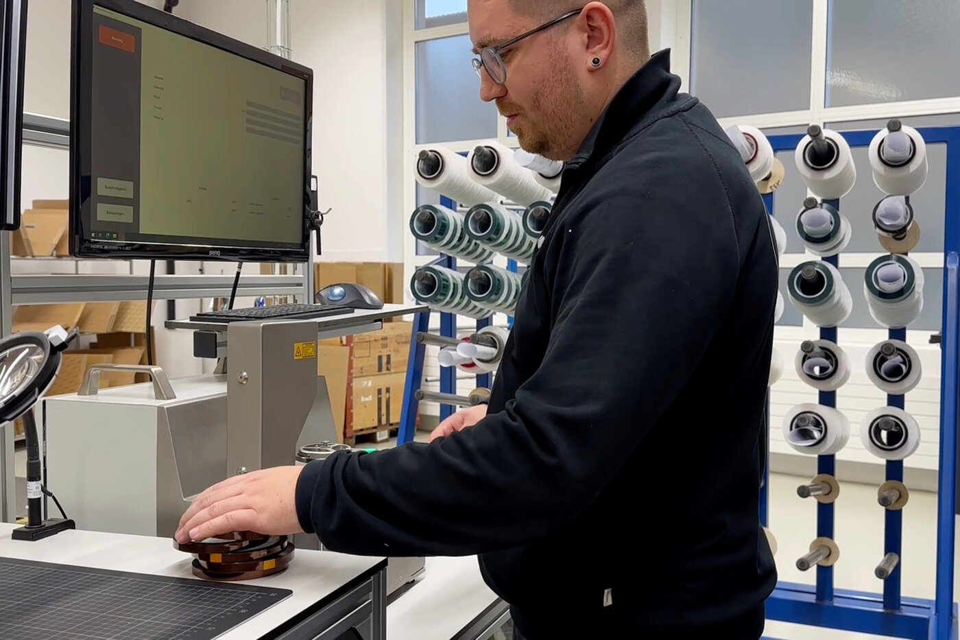 Mann prüft Schneidgenauigkeit von Klebebändern