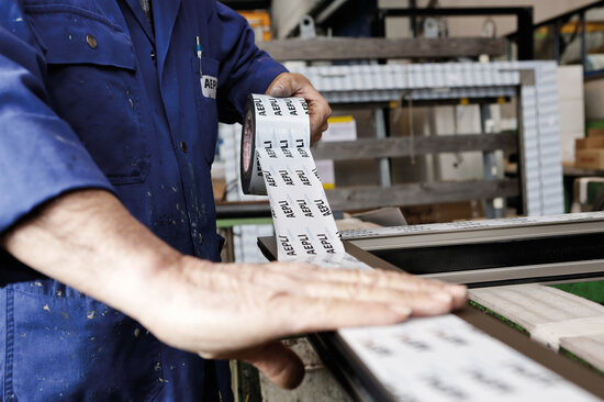 Eine bedruckte Oberflächenschutzfolie wird auf einen Fensterrahmen geklebt.