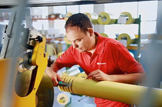 Mann misst Klebebandbreite mit Schublehre.