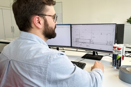 Product Manager der Permapack analysiert am PC einen Ausführungsplan eines Kunden aus der Metallbau-Branche