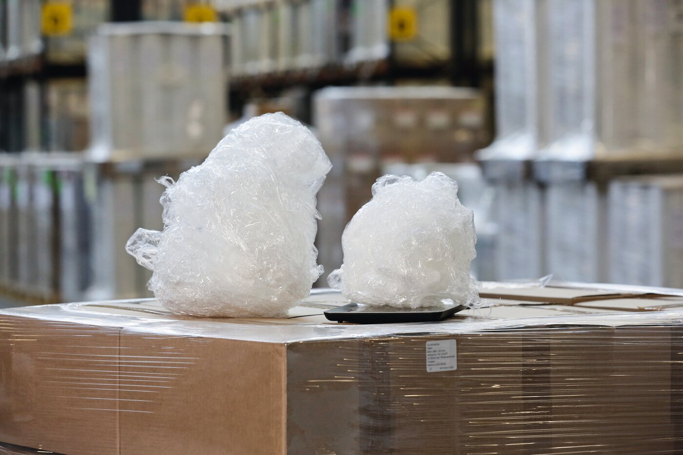 Ein grösseres und ein kleineres Knäuel Stretchfolie liegen nebeneinander auf einer Palette.