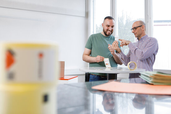 Zwei Personen begutachten eine Etikette. 