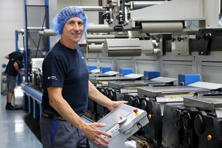 Mitarbeiter bedient eine Druckmaschine.
