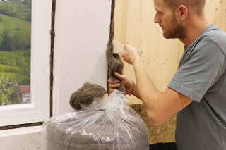 Mann drückt Dämmzopf in eine Fuge