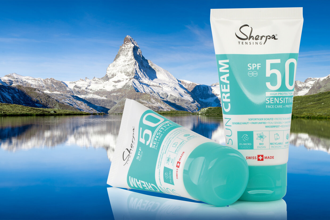 Im Hintergrund das Matterhorn und ein See und im Vordergrund zwei Laminattuben mit Sherpa-Sonnencrème