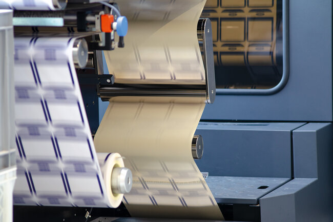 Ausschnitt der Digitaldruckmaschine HP Indigo mit Druckmaterial.