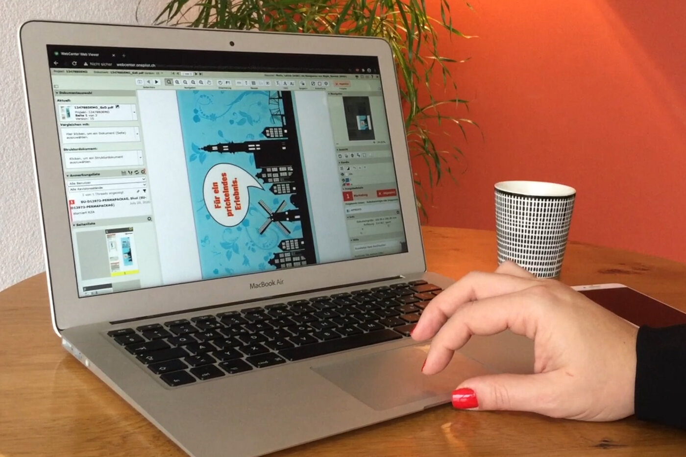 Geöffneter Laptop mit einem Druckmuster auf dem Bildschirm und eine Hand schwebt über dem Touchfeld