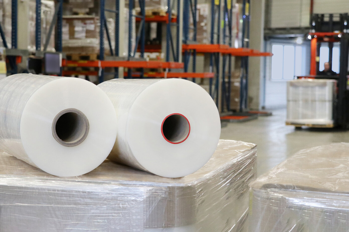 Zwei Rollen Stretchfolien liegen nebeneinander, die rechte hat einen kleineren, roten Rollenkern.