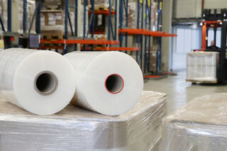 Zwei Rollen Stretchfolien liegen nebeneinander, die rechte hat einen kleineren, roten Rollenkern.