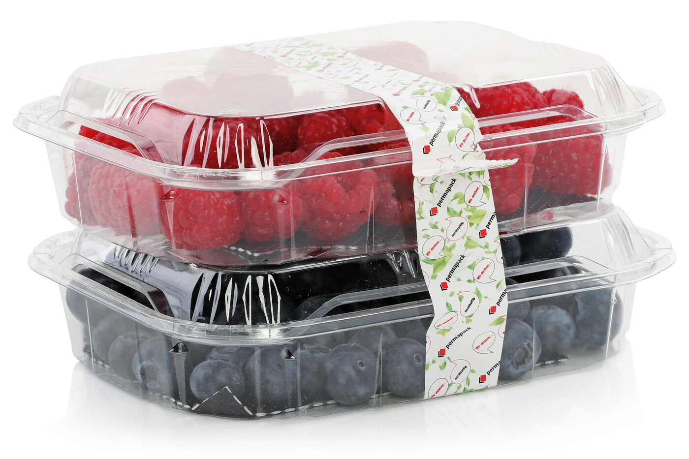 Zwei transparente gedeckte Schalten mit Himbeeren und Heidelbeeren, umwickelt mit einer nachhaltigen Endlos-Etikette für die Lebensmittelindustrie.