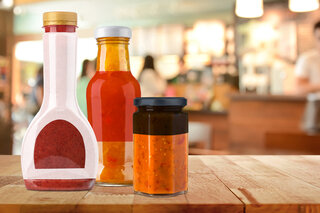 Drei verschieden Gläser. Das kleinste Gefäss hat einen schwarzen Deckel, der mittlere hat einen roten Körper und der grösste hat eine weisse Folie. 