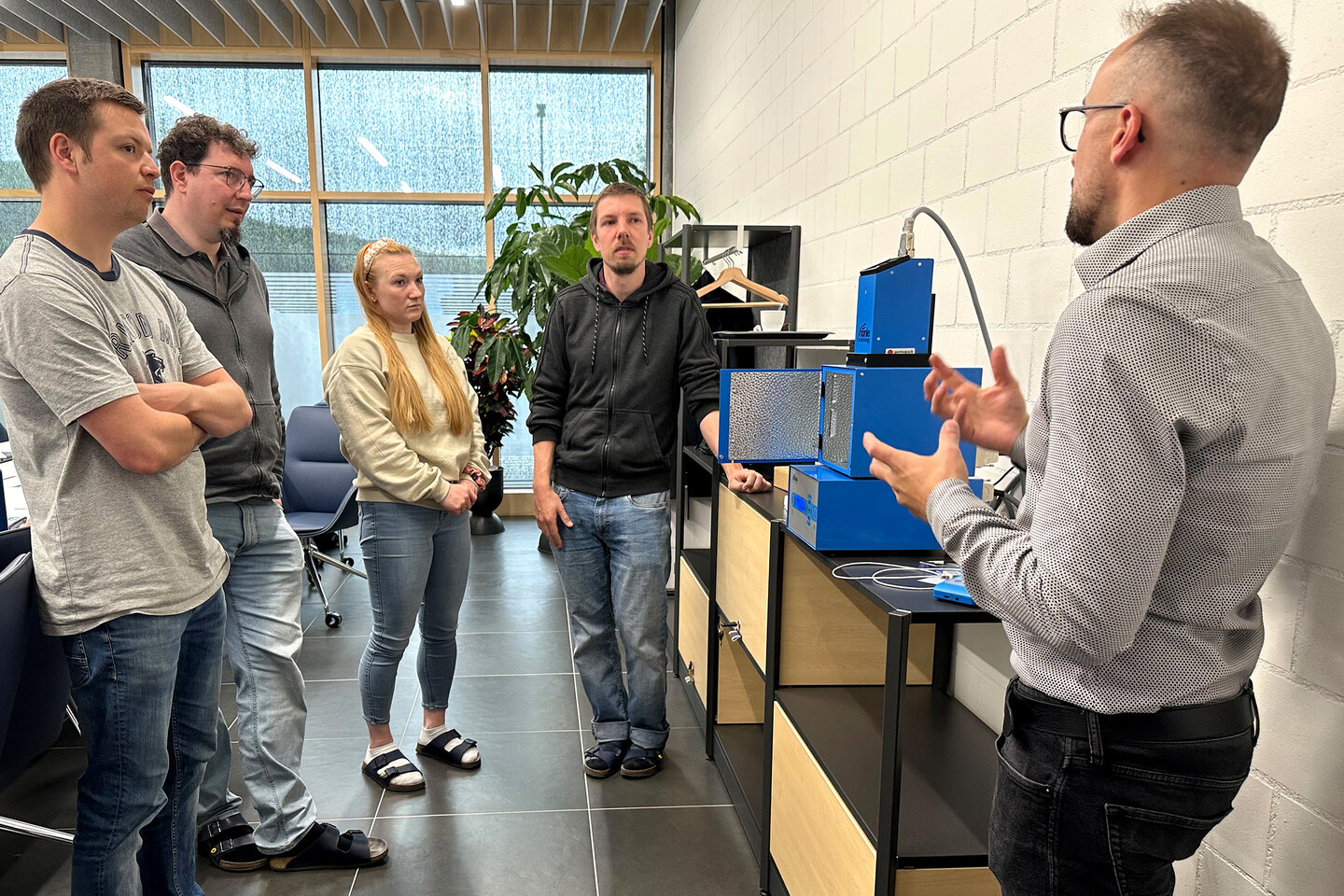 Ein Mitarbeiter der Permapack erzählt den Mitarbeiter der Brütsch-Elektronik-AG über Permapack und die Produkte