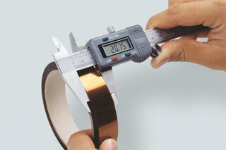 Die Klebebandbreite wird mit einer Schieblehre geprüft.