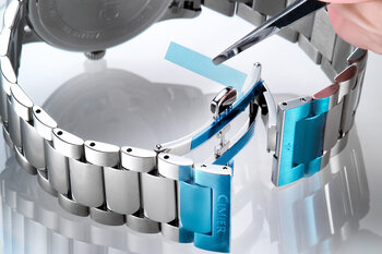 Blautransparente Formstanzteile auf einem Metall-Uhrenarmband.