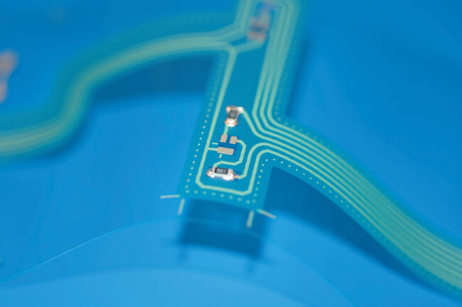 Mise en contact et collage de composants sur un circuit imprimé flexible 