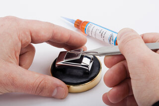 Ein Uhrenglas wird mit UV-Kleber auf einem Uhrengehäuse fixiert. 