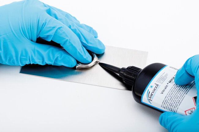 Ein Uhrengehäuse wird mit wasserlöslichem Vitralit-MASK-Kleber temporär fixiert.