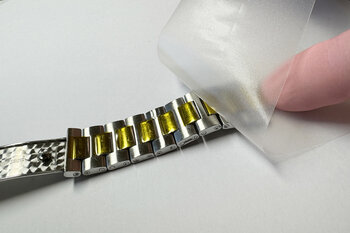 Tri-Couche-Formstanzteil wird auf ein Uhrenarmband appliziert.