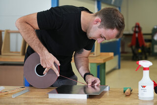 Metallbauer bringt ein VST-Montageklebeband auf einer Metallplatte an. 