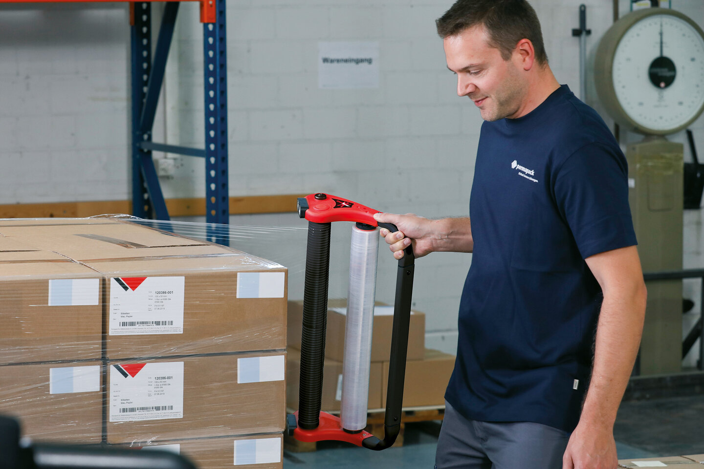 Mann mit dem ENOergo Handabrollgerät für Stretchfolie