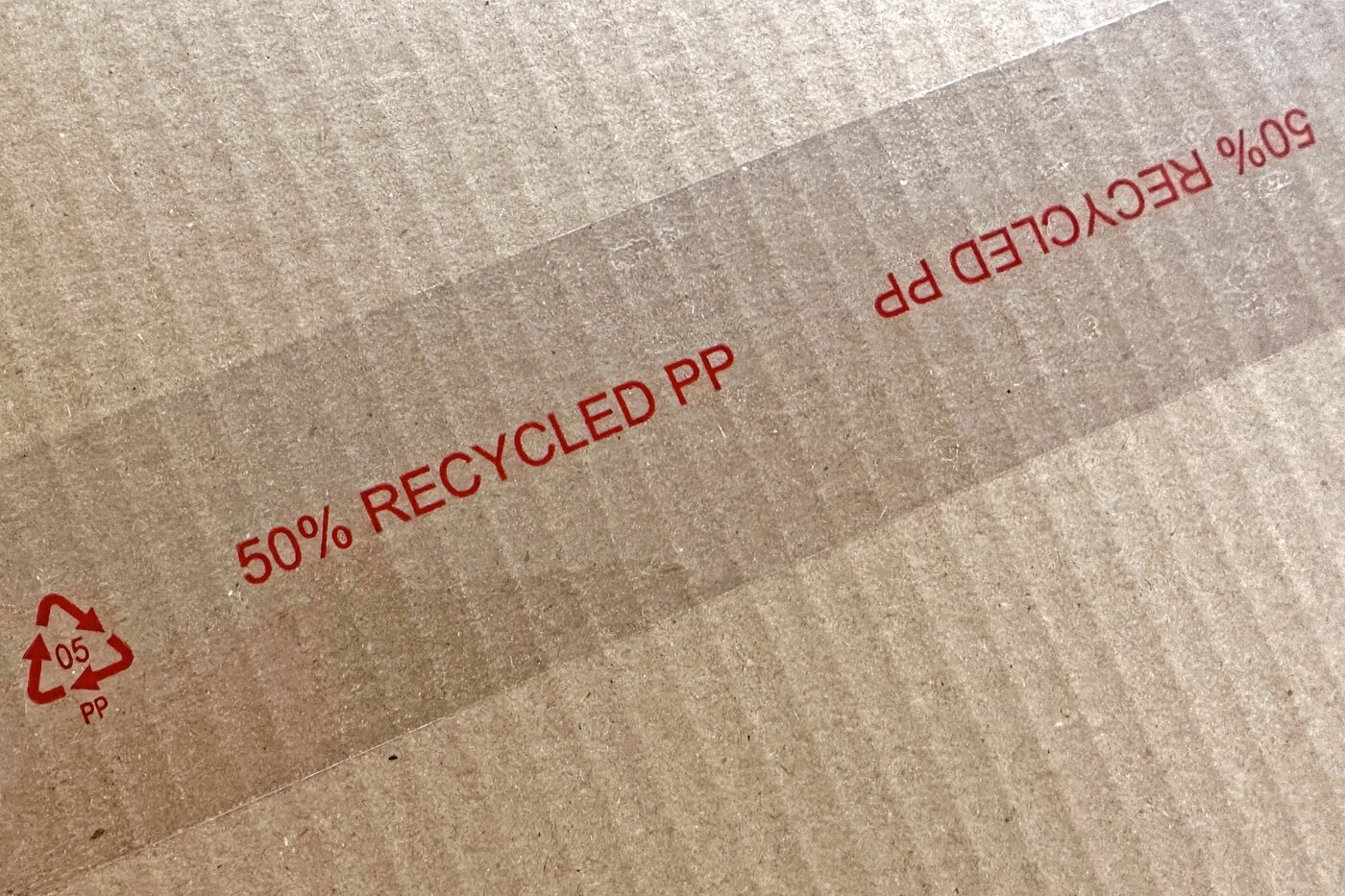 Aufdruck in roter Schrift auf dem Packband: 50% RECYCLED PP 