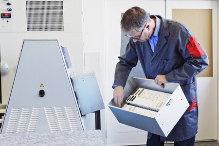 Permapack-Mitarbeiter vor der Verwitterungsmaschine