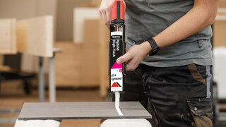 Mann hält Kartuschenpresse für gängige Dichtsoffe