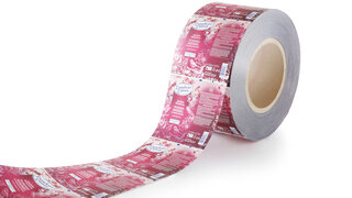 Eine abgerollte Rolle in Rottönen bedrucktem Tubenlaminat.