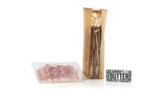 In Verbund- und Barrierefolien verpacktes Trockenfleisch und eine in Butterwickelfolie eingepackte Butter. 