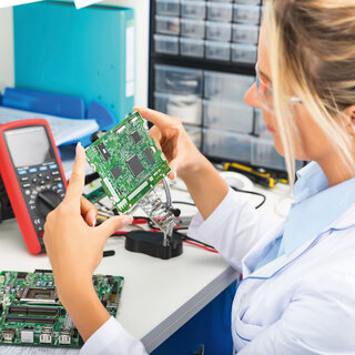 Frau prüft Leiterplatte.