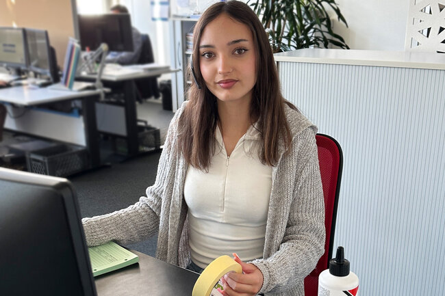 Lernende Kauffrau sitzt am PC. 