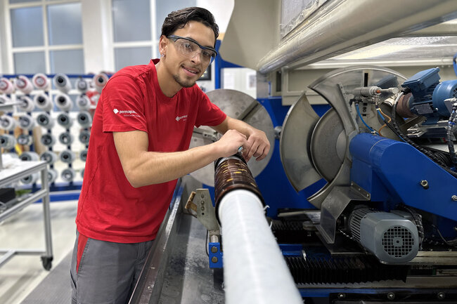 Lernender Anlagenführer an einer Rollenschneidmaschine