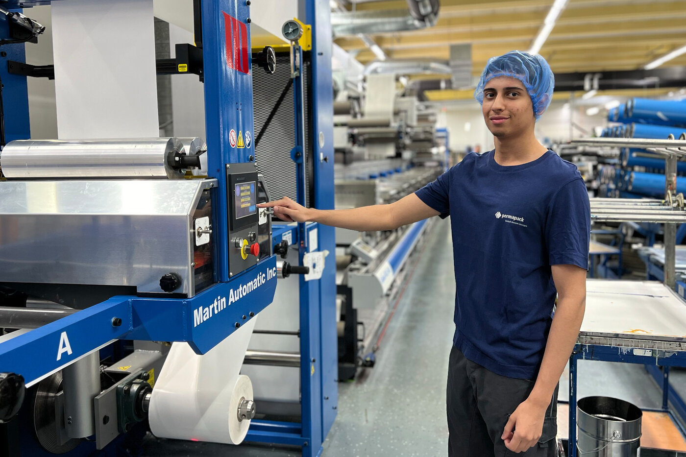 Lernender, beim Einstellen der Druckmaschine. 