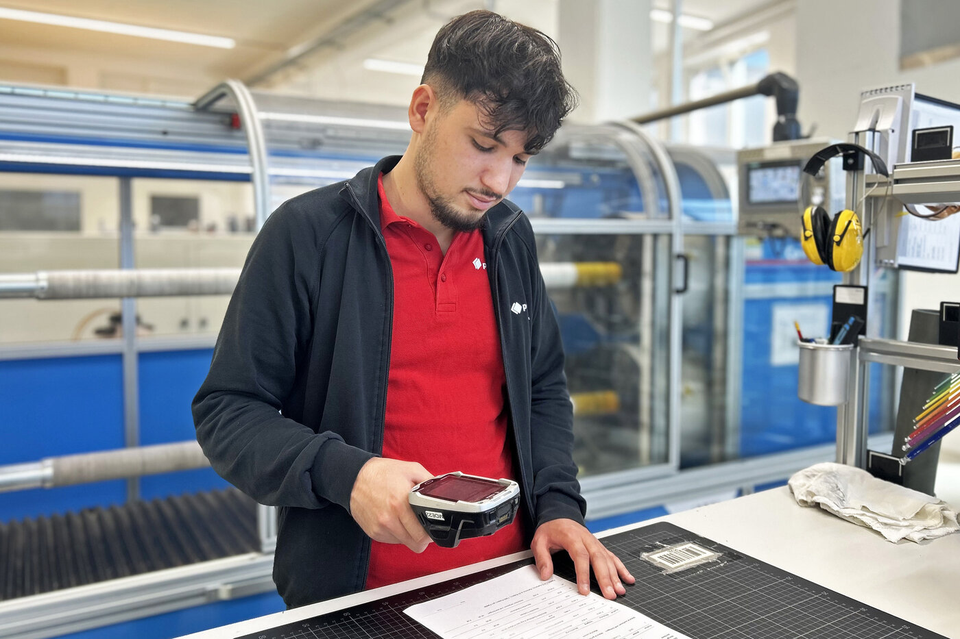 Lernender beim Scannen eines Produktionsauftrags. 