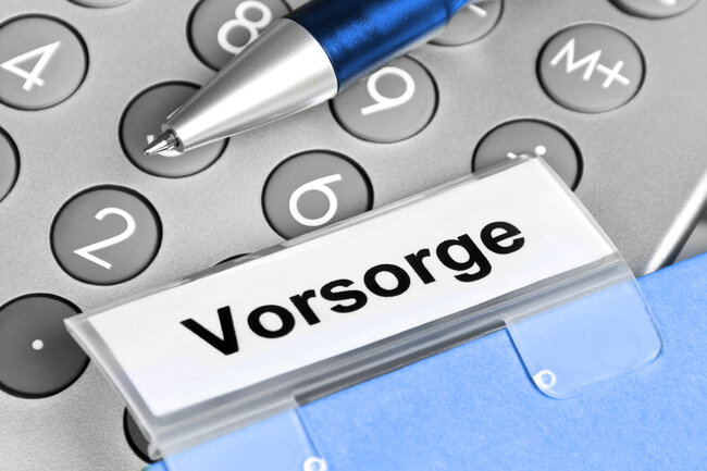 Beschrifteter Ordner «Vorsorge» auf einem Taschenrechner mit Kugelschreiber.