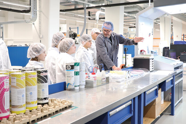 Mann mit einer Schar Kindern am Zukunftstag in der Permapack