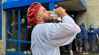 Ein frisch getaufter Drucker trinkt ein Glas Bier aus.