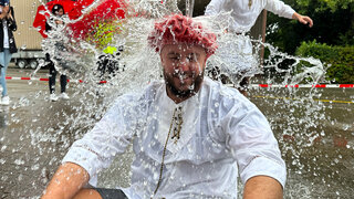 Ein Mann wird bei einer Gautsch-Zeremonie mit Wasser übergossen. 