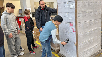 Ein Junge scannt mit einem Handscanner eine Etikette.