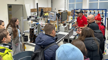 Eine Gruppe Kinder vor dem Rollenbreitenmessgerät