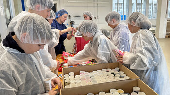 Kinder füllen leere Tuben-Rohlinge mit Süssigkeiten