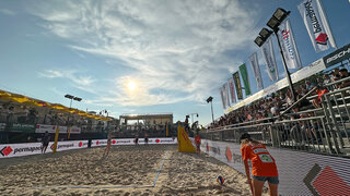 Beachvolleyball Center Court in der Abendsonne. Die Werbebande zeigt das Permapack-Logo. (