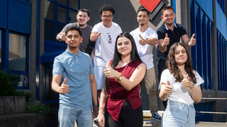 Gruppenbild von 7 Lernenden, die sich über ihren Lehrabschluss freuen. (