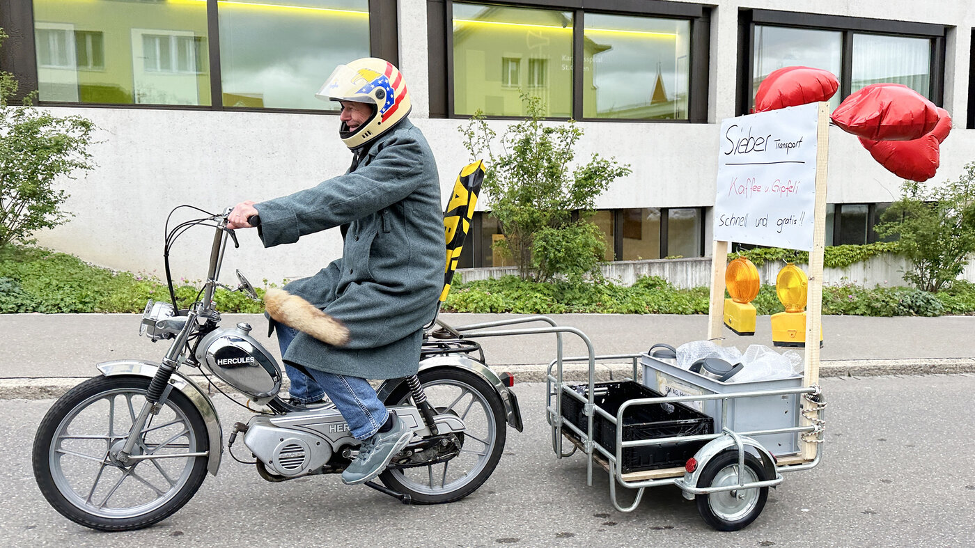 Peter Sieber auf dem Töfli mit Kaffee und Gipfeli im Anhänger. 