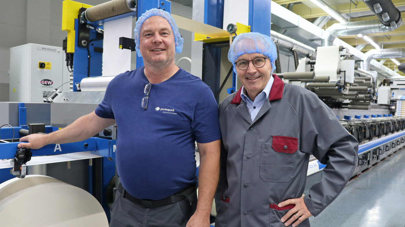 Jubilar Hannes Staib mit CEO Thomas Hansmann vor einer Druckmaschine