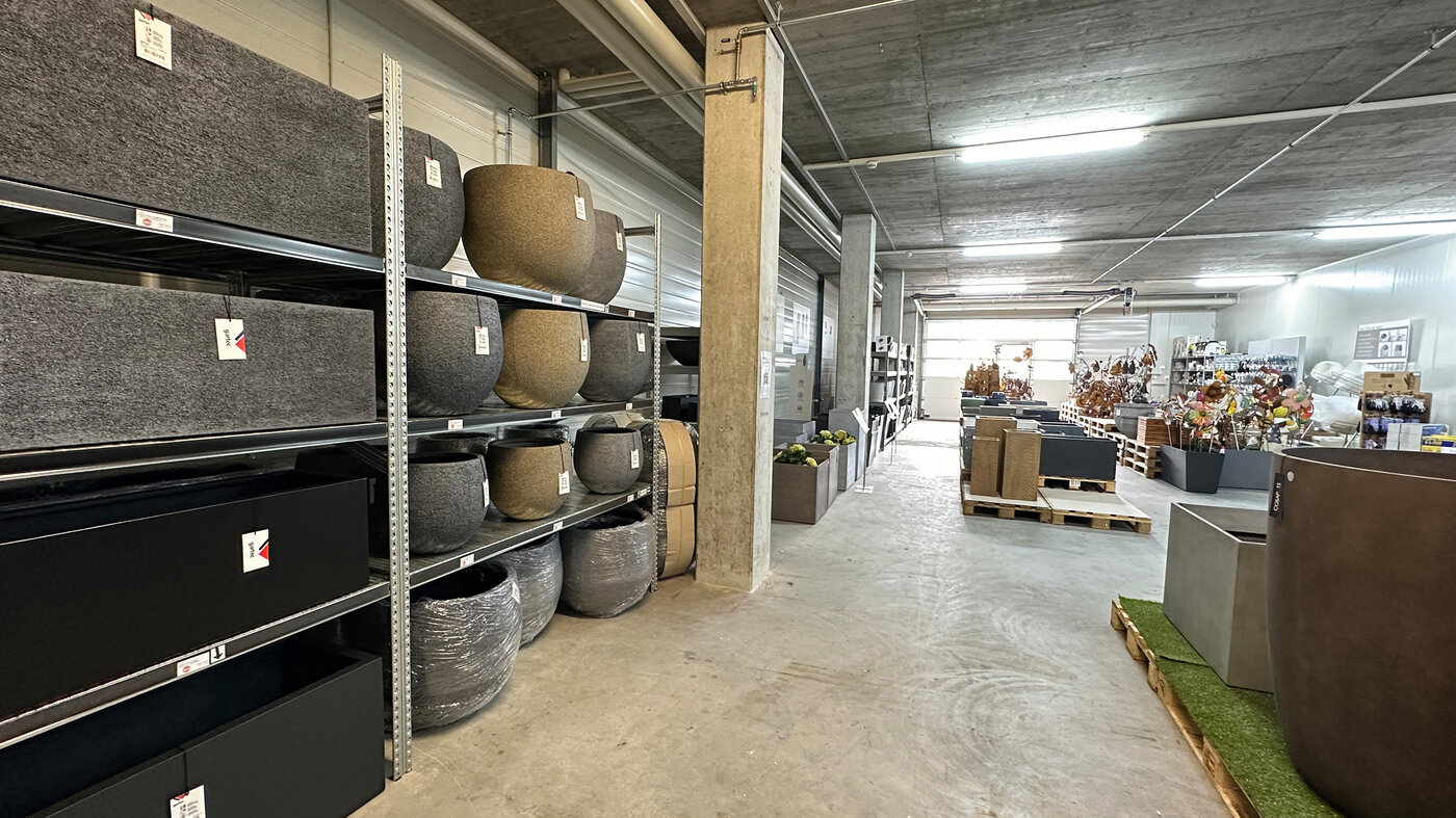 Innenansicht Permapack Lagerverkauf mit gartec Fiberstone Gefässen in Regalen sowie weiteren ausgestellten Pflanzengefässen
